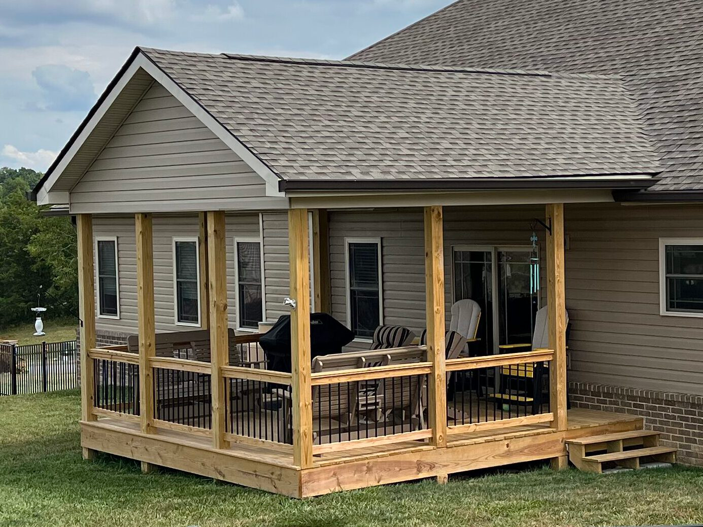 Covered wood porch, with stairs, siding, soffit, and new shingle roof.